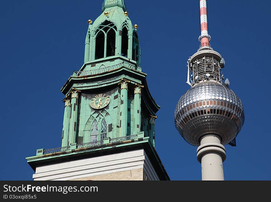 Closeup of the Berlin TV tower and the clock tower of the Nikolai church near Alexanderplatz. Closeup of the Berlin TV tower and the clock tower of the Nikolai church near Alexanderplatz.