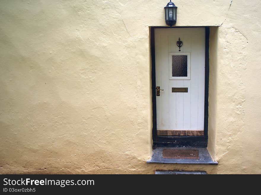 A rendered wall with a white door.