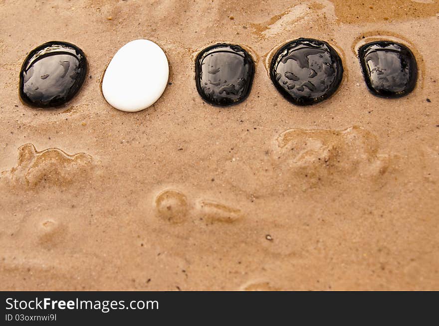 Black and white stepping stones in water and sand. Black and white stepping stones in water and sand