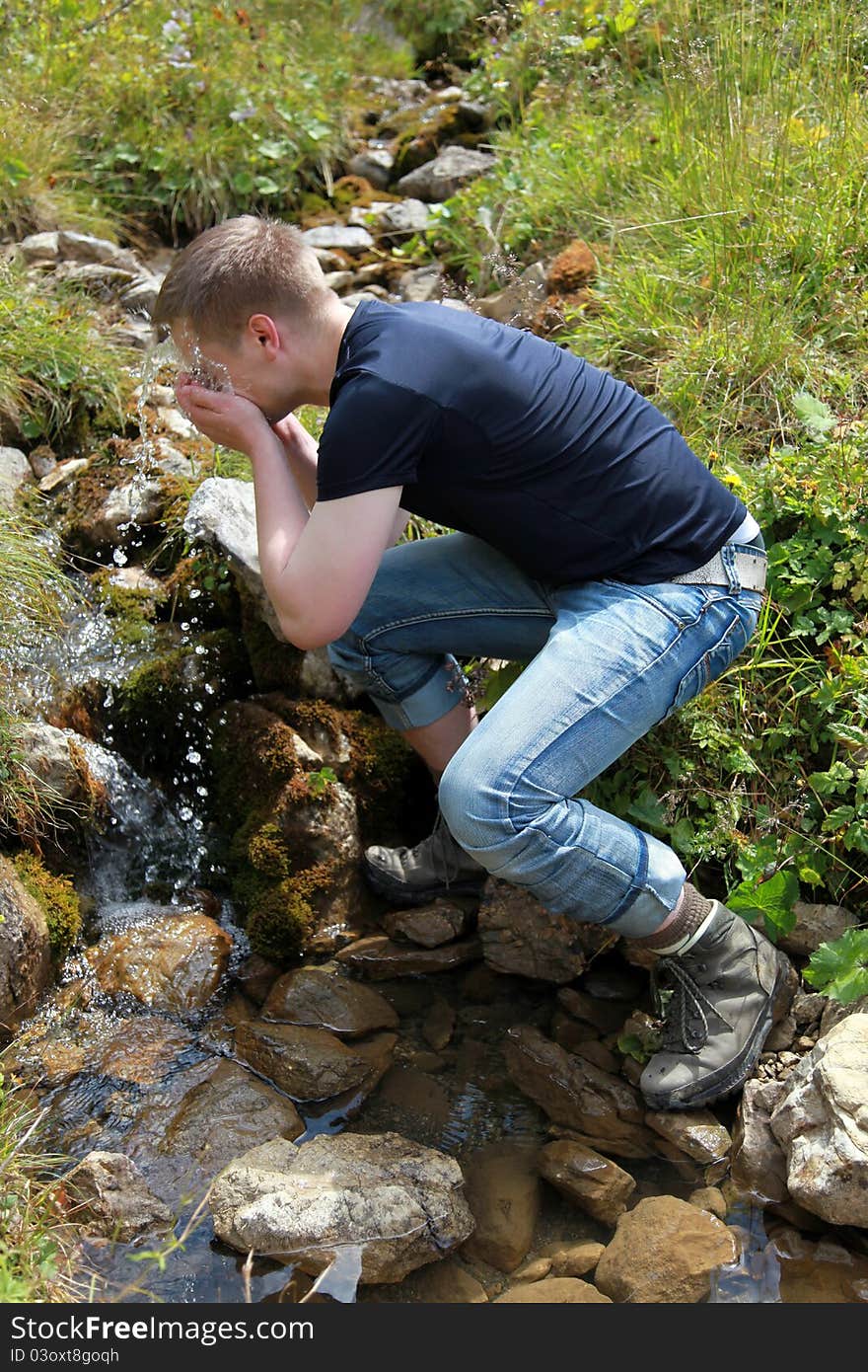 Young man taking a refreshment in the mountains