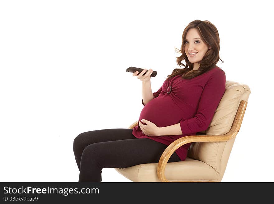 A pregnant woman sitting and watching tv.