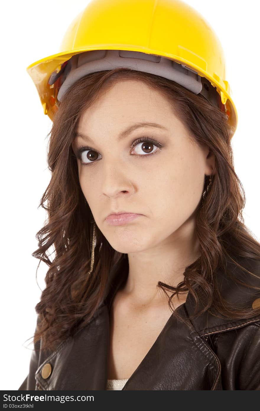 A close up of a woman in her construction hat with a sad expression on her face. A close up of a woman in her construction hat with a sad expression on her face.