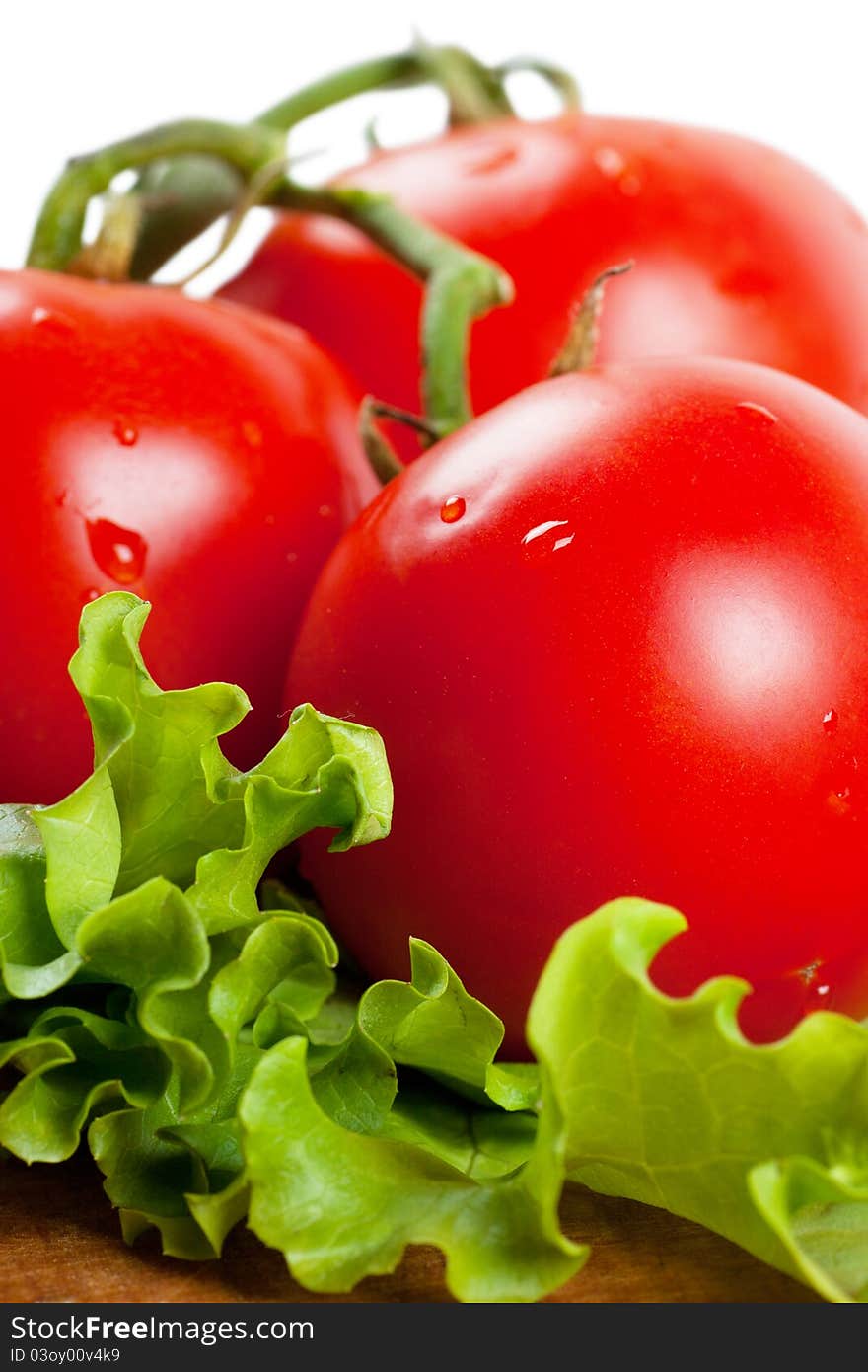 Closeup view of three tomatoes on a lettuce leaf