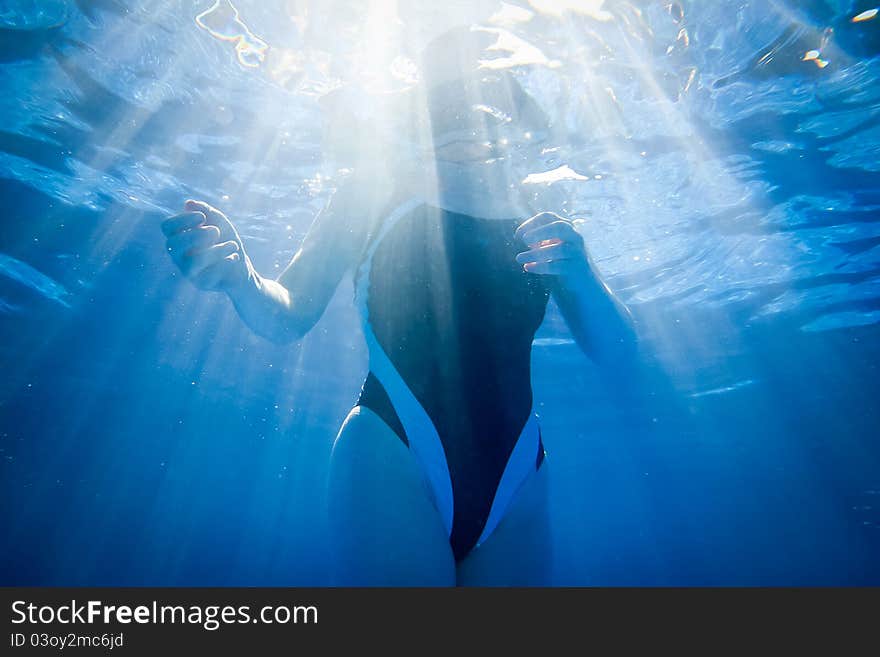 A swimmer floating in light beams. A swimmer floating in light beams