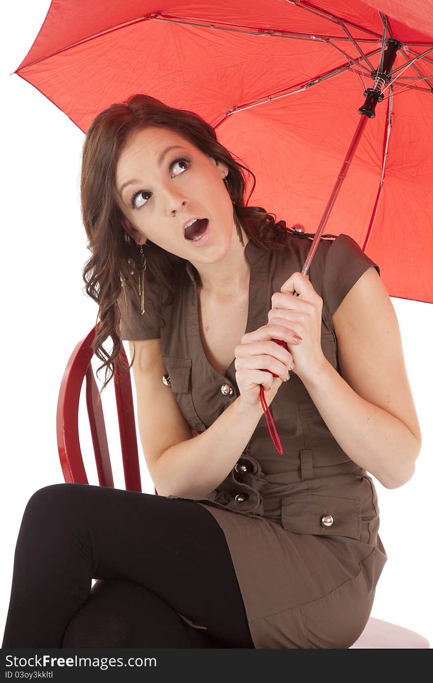 Woman on red chair look from under umbrella