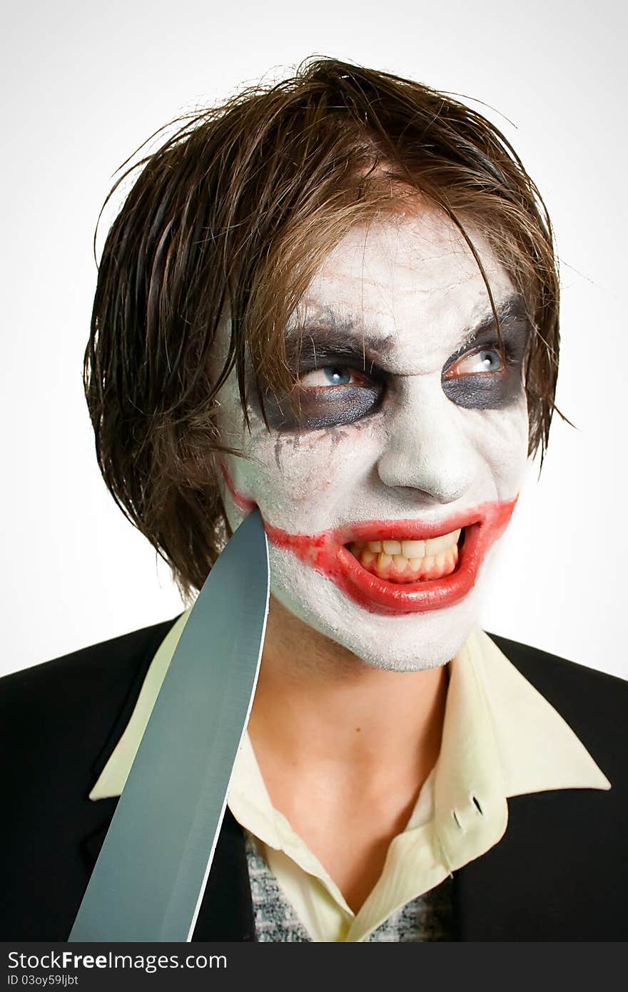 Portrait of young joker cutting his smile. Portrait of young joker cutting his smile