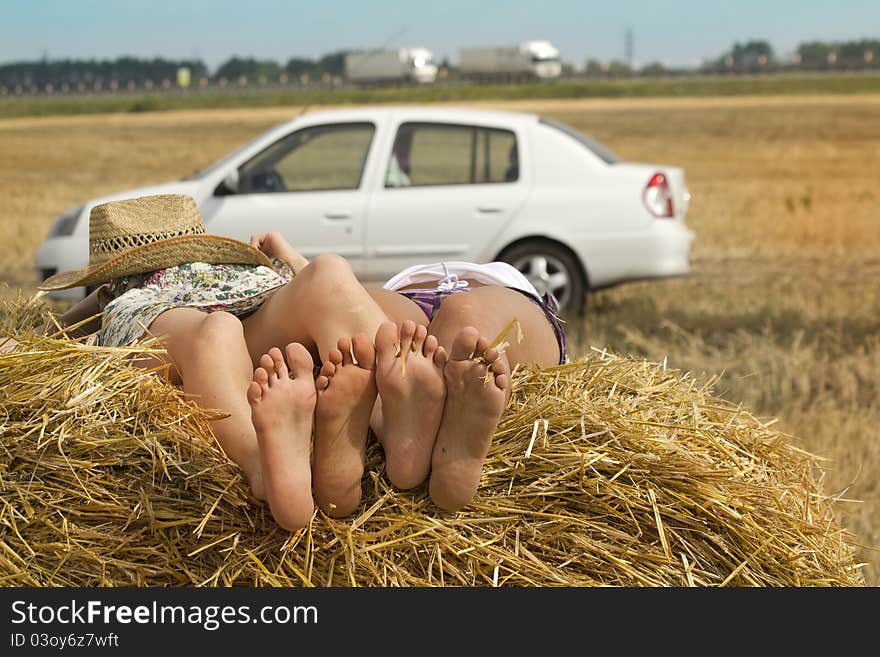 Women traveling in a car resting in a field in a haystack. Women traveling in a car resting in a field in a haystack