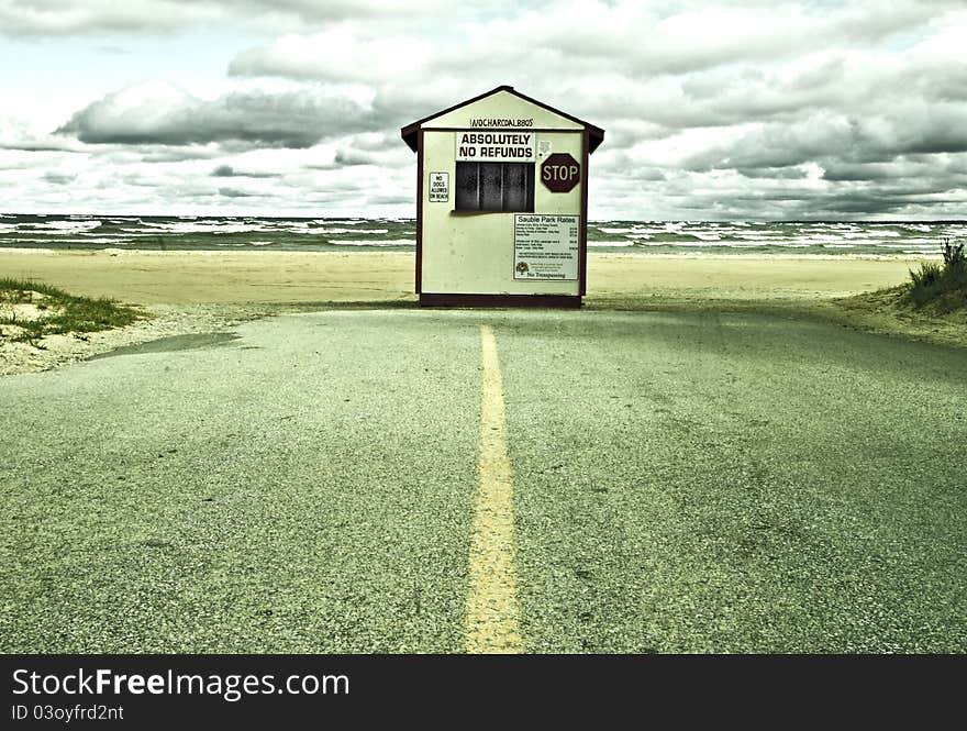 Toll booth where road ends on beach. Stormy weather.Manipulated image. Toll booth where road ends on beach. Stormy weather.Manipulated image.