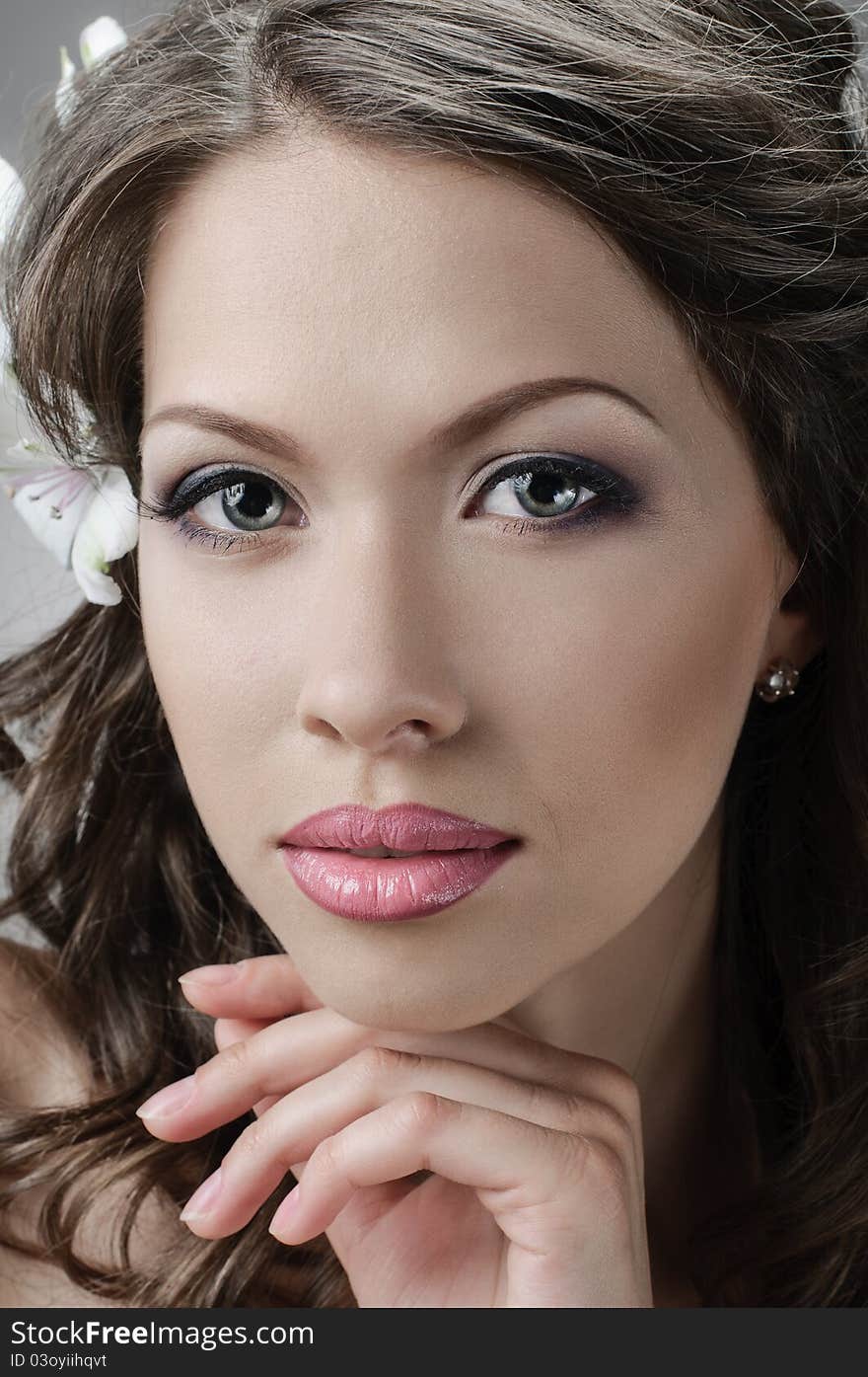 Portrait of beautiful bride with flowers in hair on grey. Portrait of beautiful bride with flowers in hair on grey