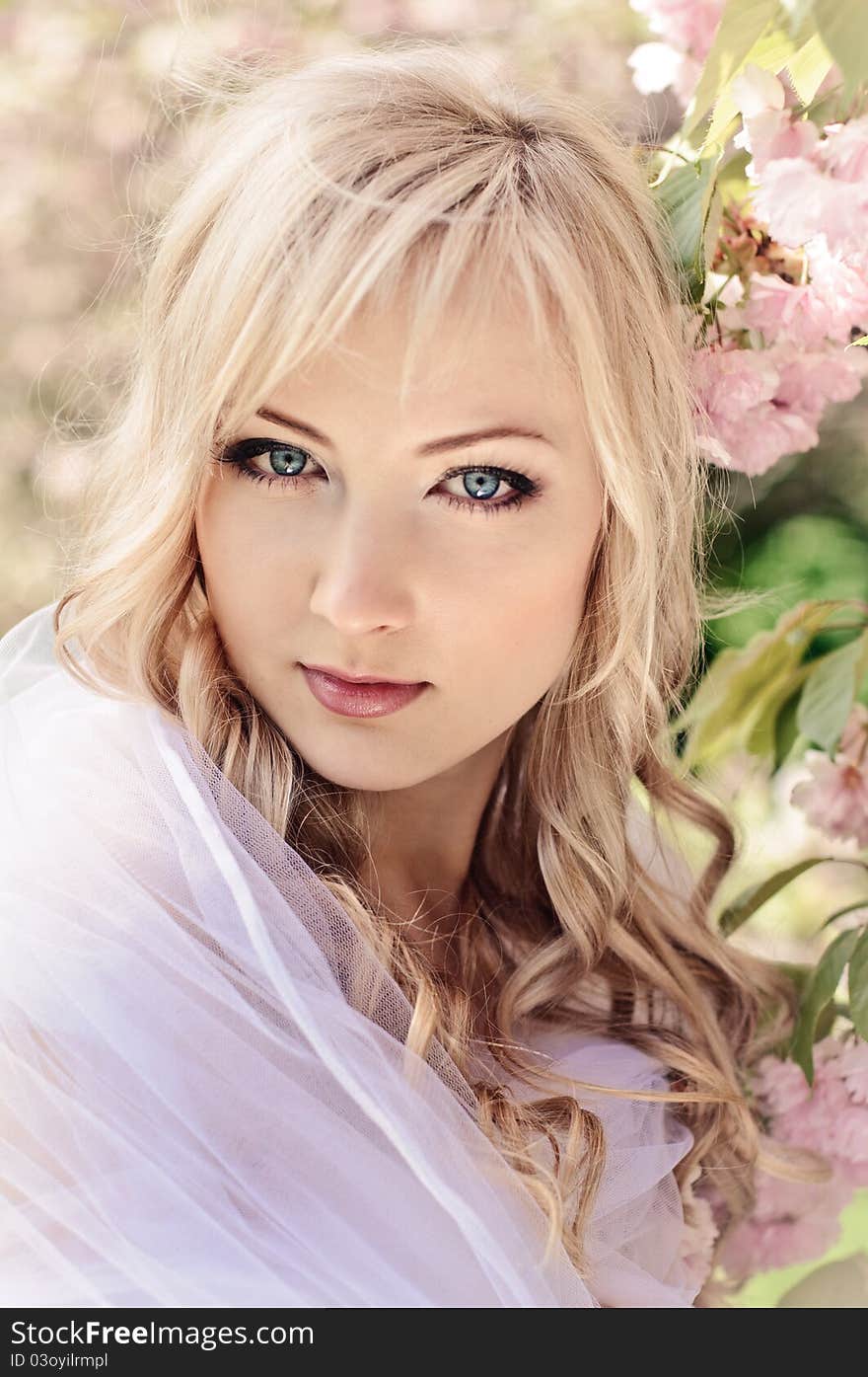 Portrait of beautiful girl with white kerchief and blooming sakura on background. Portrait of beautiful girl with white kerchief and blooming sakura on background