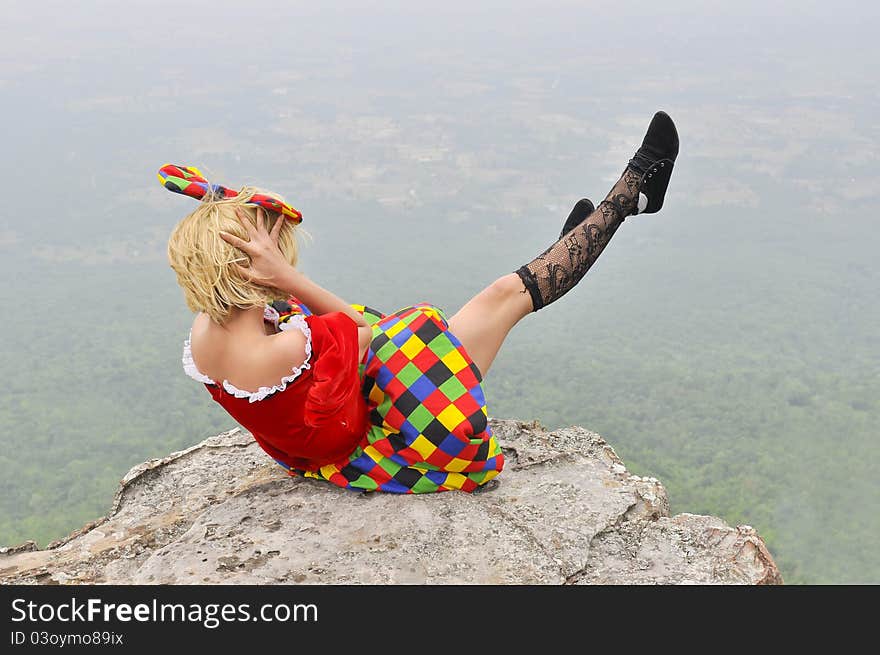 Beautiful young woman playing on the cliff