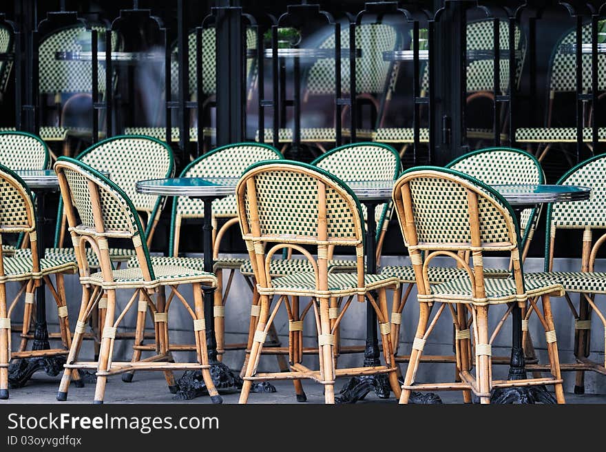 Wicker chairs in the typical cafe in Paris. Photo with tilt-shift effect. Wicker chairs in the typical cafe in Paris. Photo with tilt-shift effect