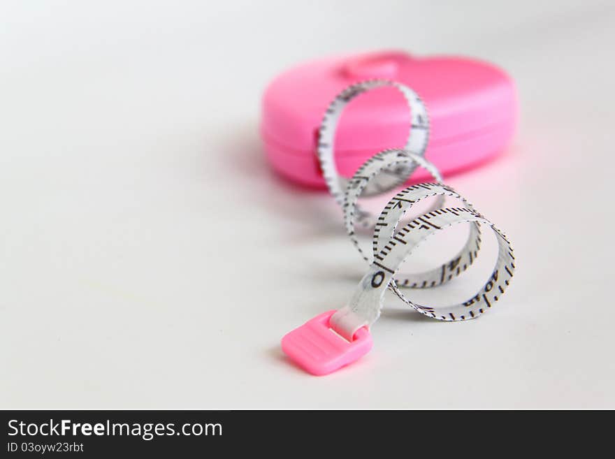 Pink heart with meter curling around on white background