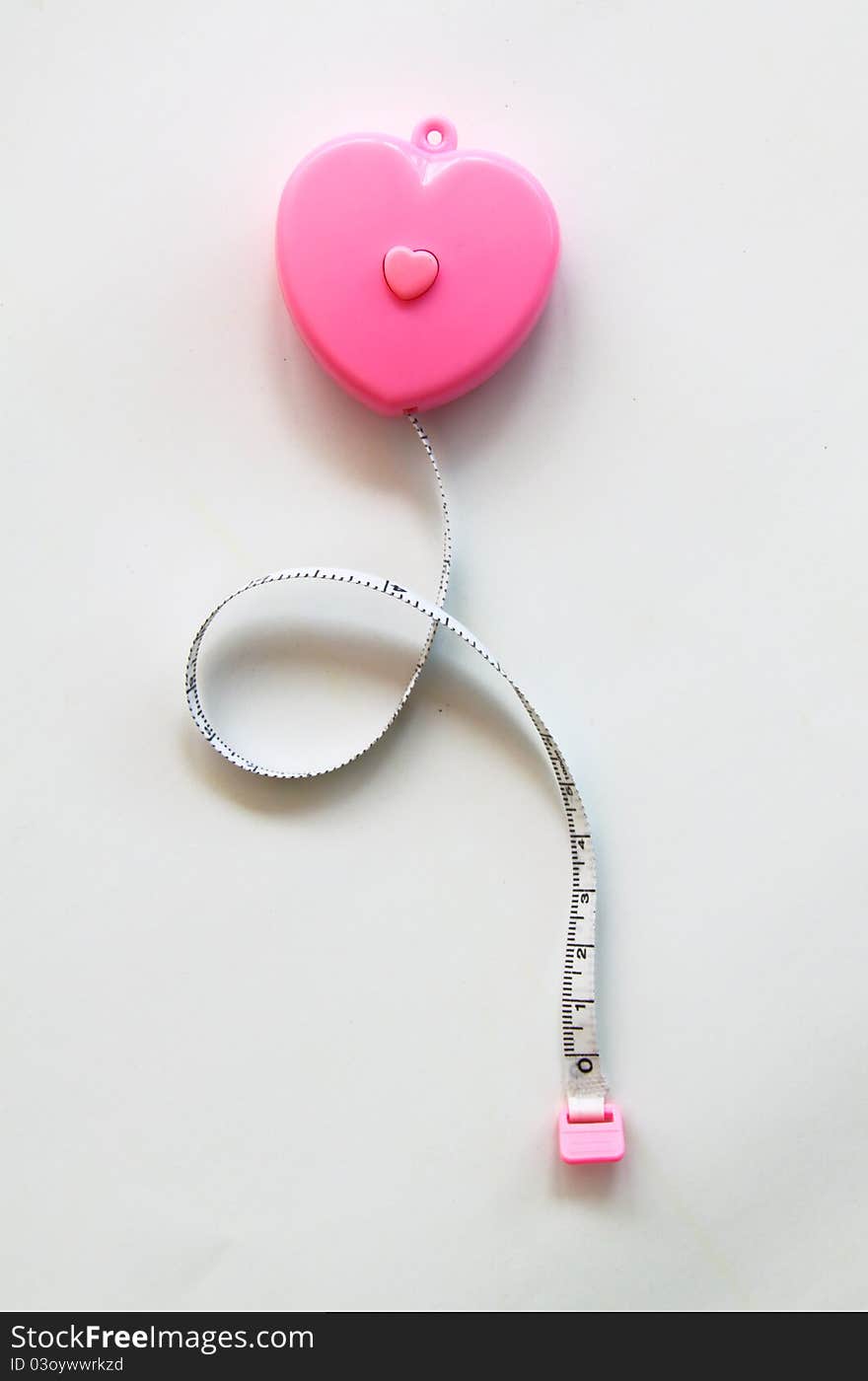 Pink heart with meter curling around on white background