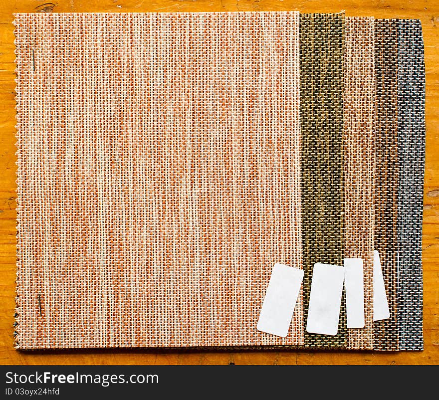 Five colors of burlap sample with little white paper tag in wooden table. Five colors of burlap sample with little white paper tag in wooden table