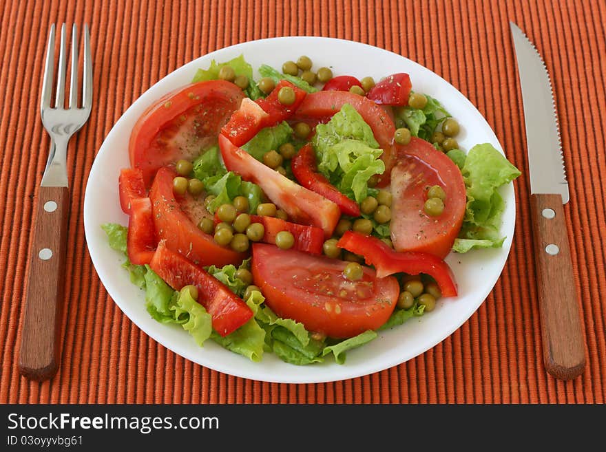 Salad with pea on an white plate