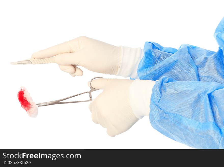 Scalpel and clamp with swab in the hand of the surgeon during a surgery. Scalpel and clamp with swab in the hand of the surgeon during a surgery