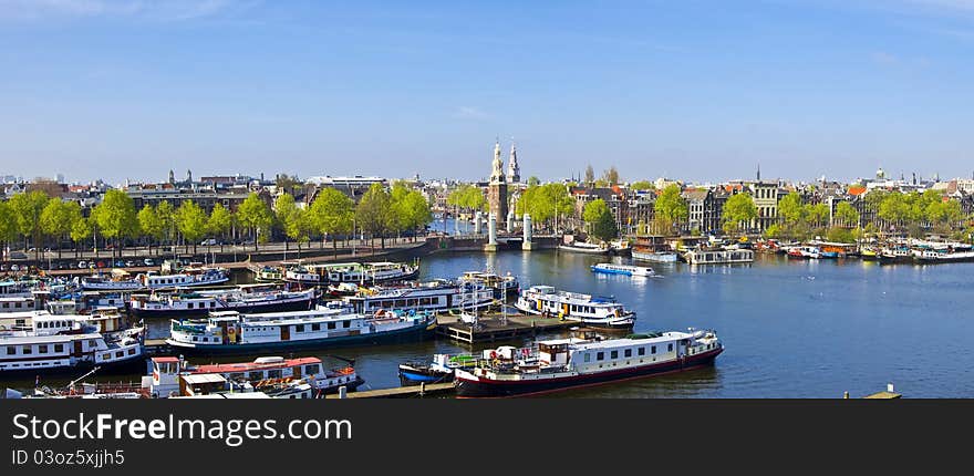 Classical Amsterdam view. Boat floats on the channel on the background of bridge. Urban scene.