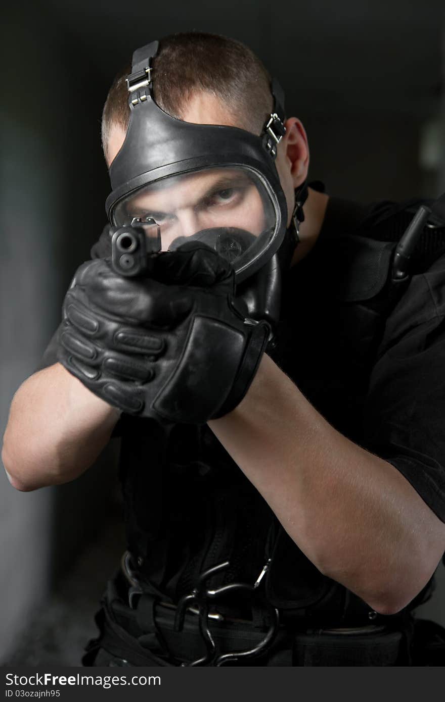 Soldier in gas mask targeting with 9mm pistol