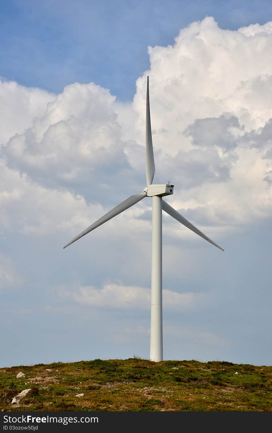 Wind turbine on a mountain with clouds