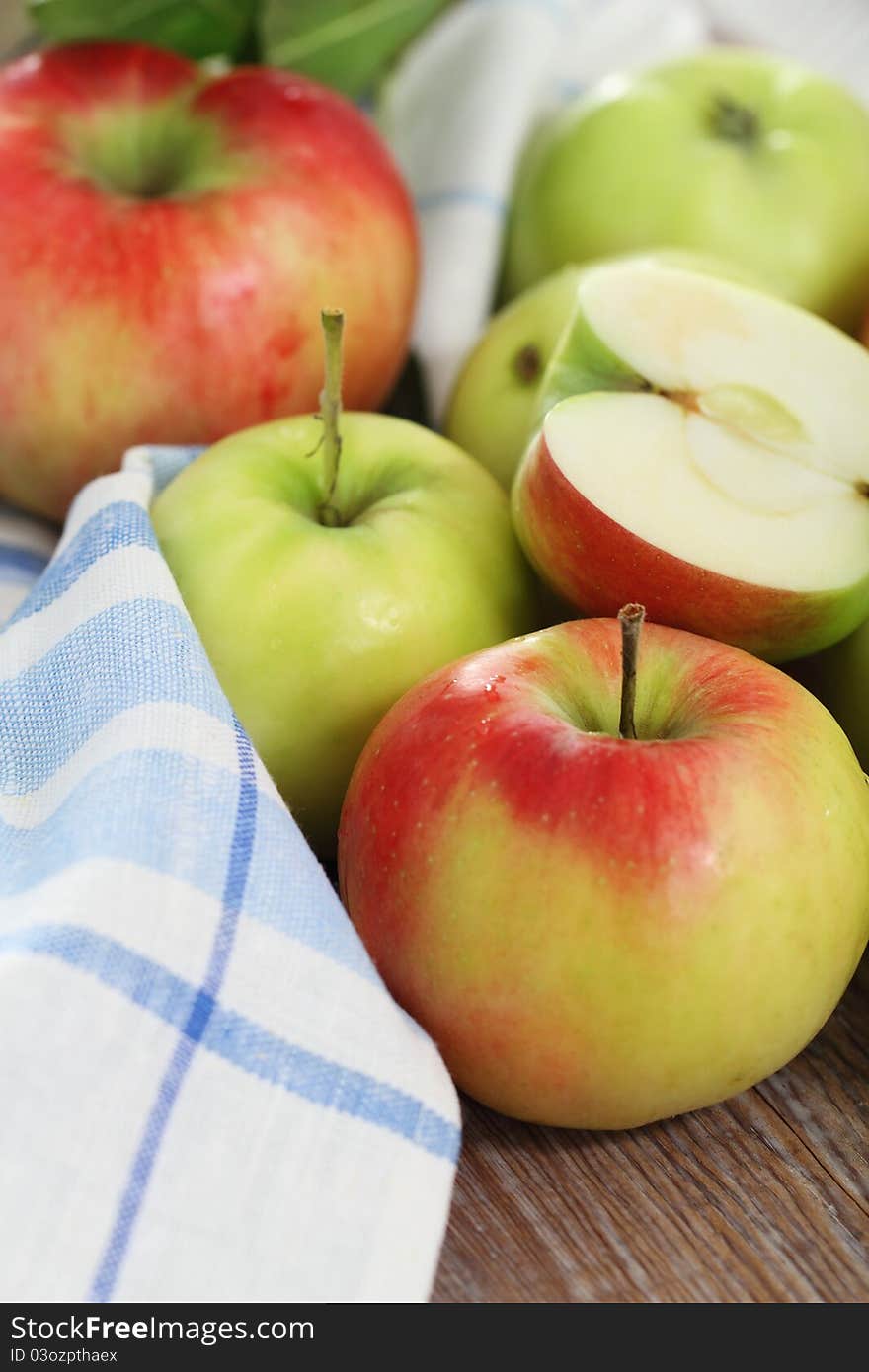 Red and green apples with leaves on the table