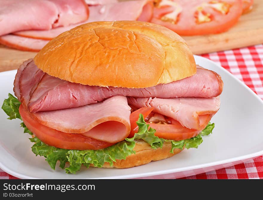 Ham sandwich with lettuce and tomato on a bun