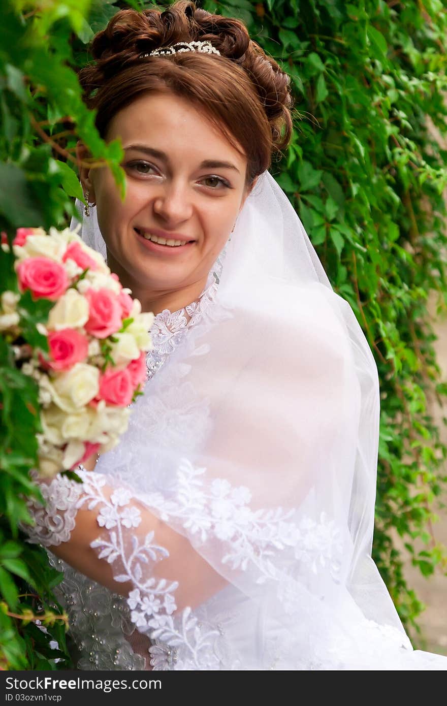 Portrait of a beautiful bride at green wall