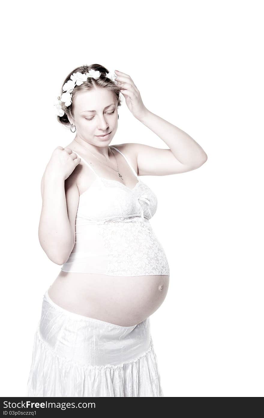 Lovely pregnant woman with flower wreath, high key. Lovely pregnant woman with flower wreath, high key