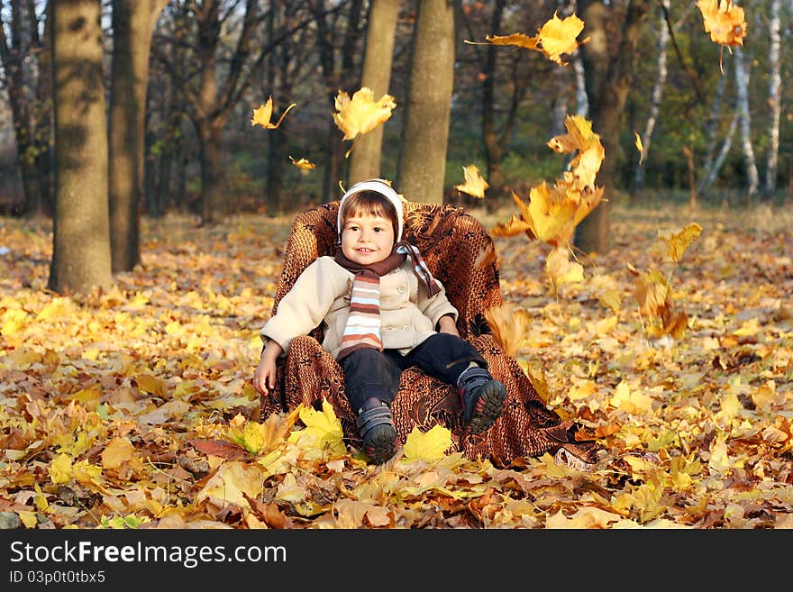 Little Boy Sitting In Chair Outdoors