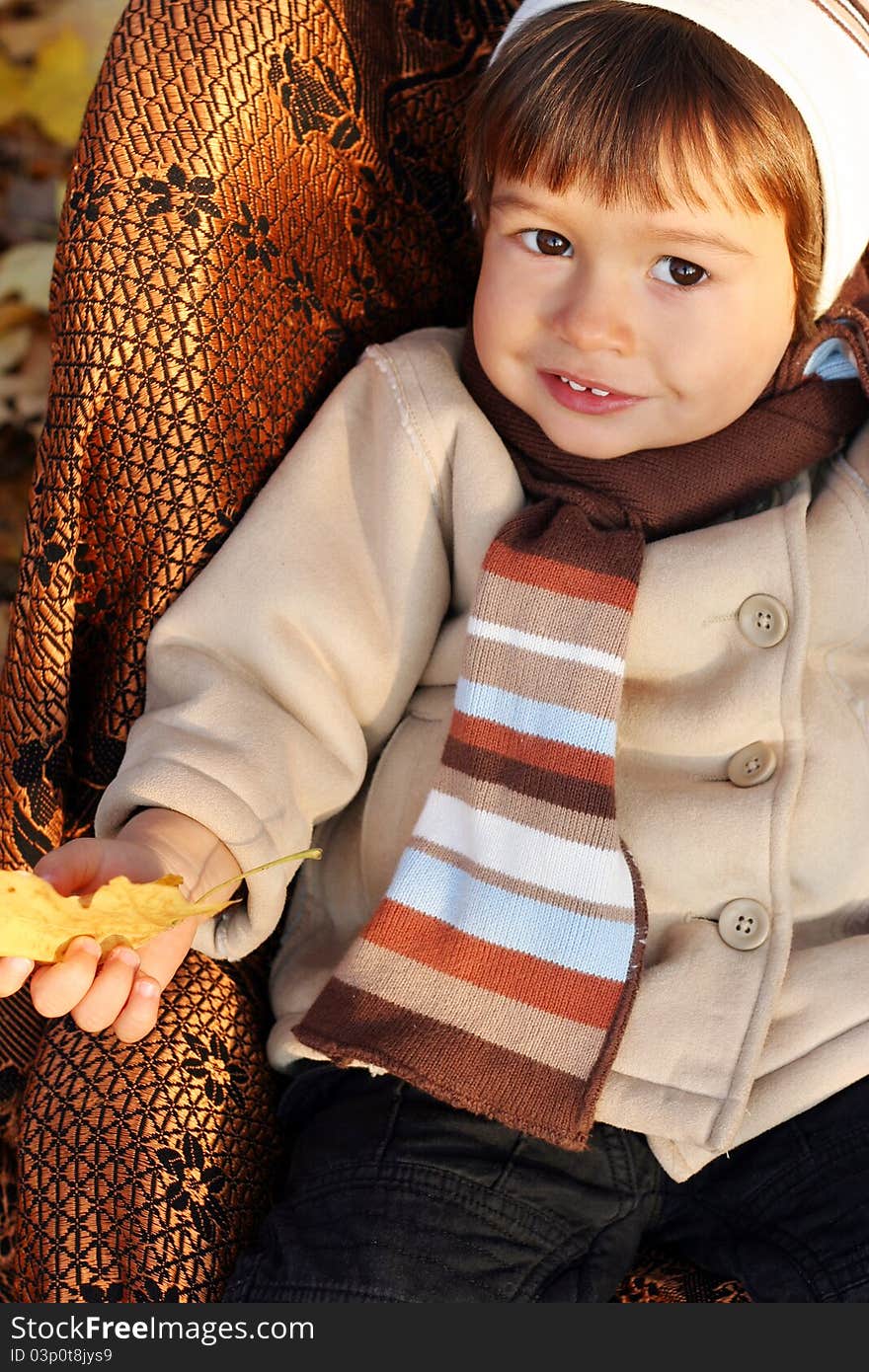 Little boy sitting in chair outdoors