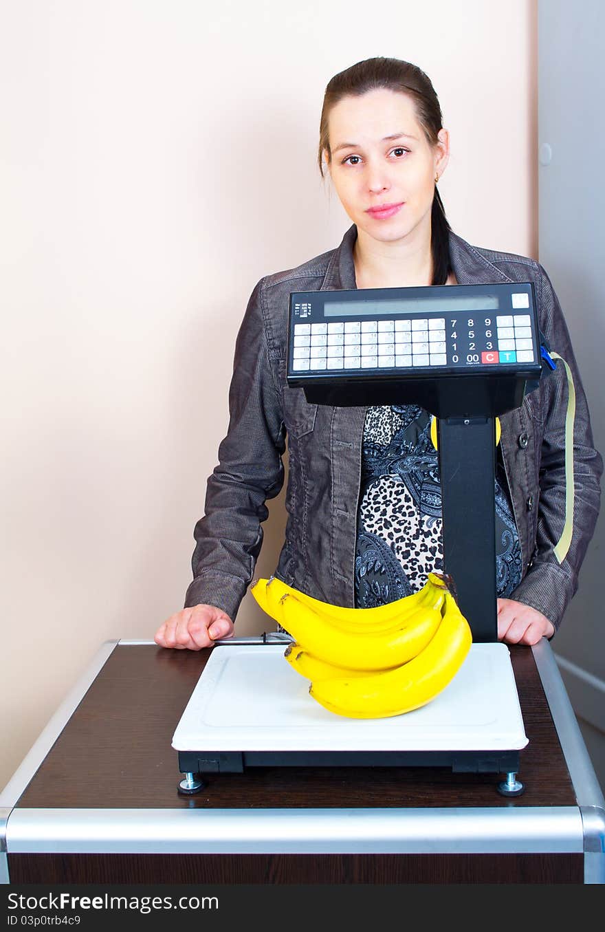 Girl weighing bananas in market