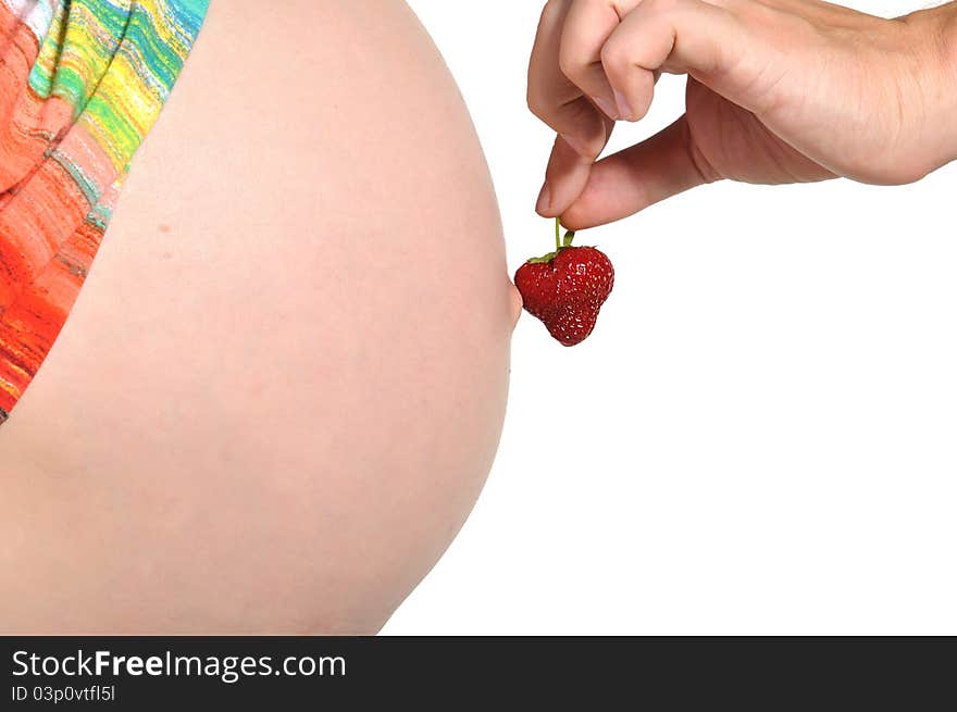 Pregnant woman holding a strawberry at her abdoman. Pregnant woman holding a strawberry at her abdoman