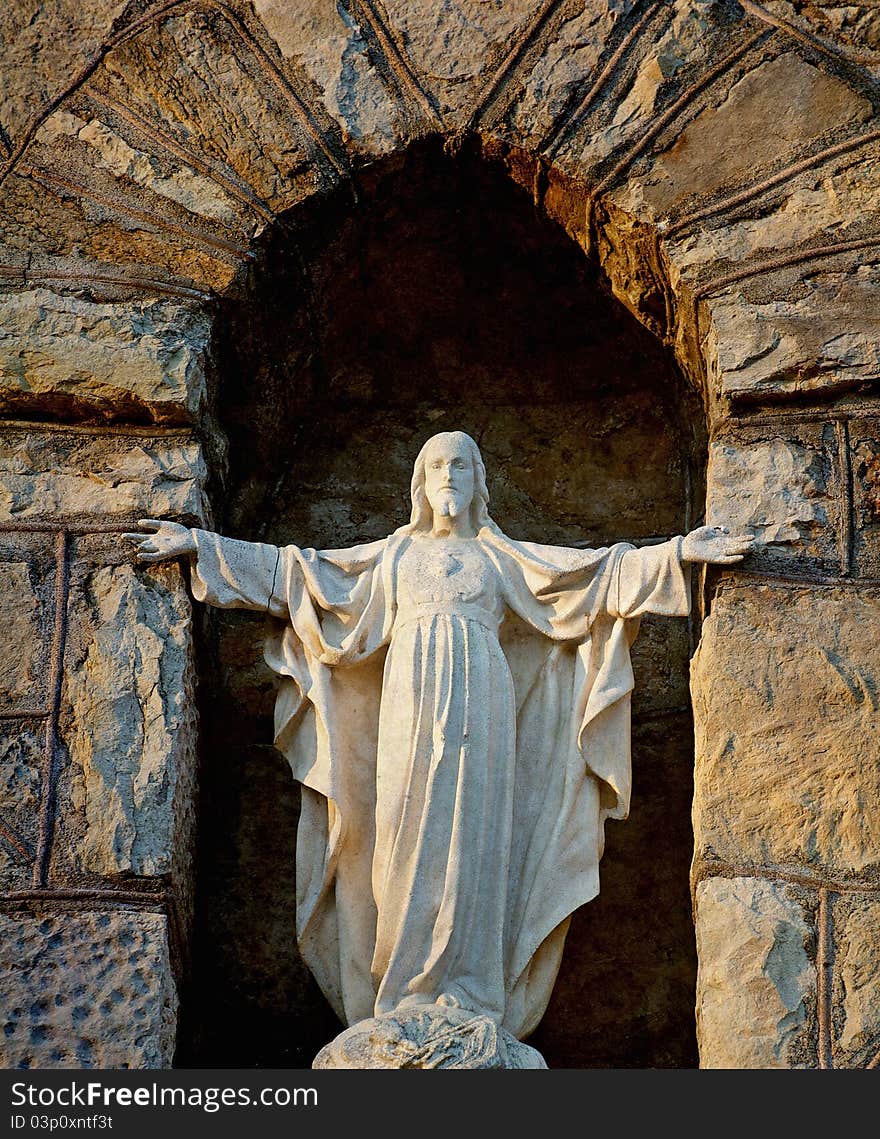 Image of an old statue of Christ in an exterior stone native church wall. Image of an old statue of Christ in an exterior stone native church wall.