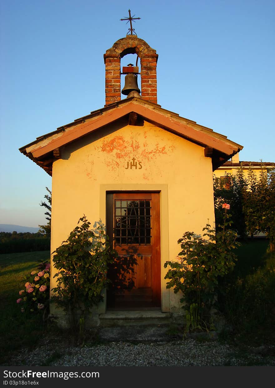 Small country church with a bell and cross, shooting at dusk in summer