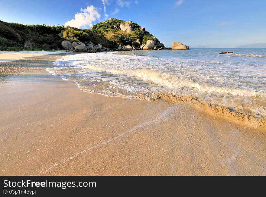 Beach sand on sea coast with rock under sunrise lighting, hown as sea coast physiognomy and landscape. Beach sand on sea coast with rock under sunrise lighting, hown as sea coast physiognomy and landscape.