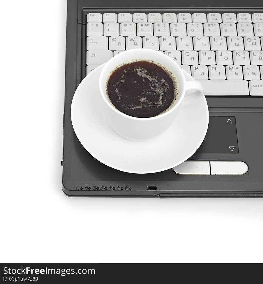 A cup of coffee on a laptop on white background