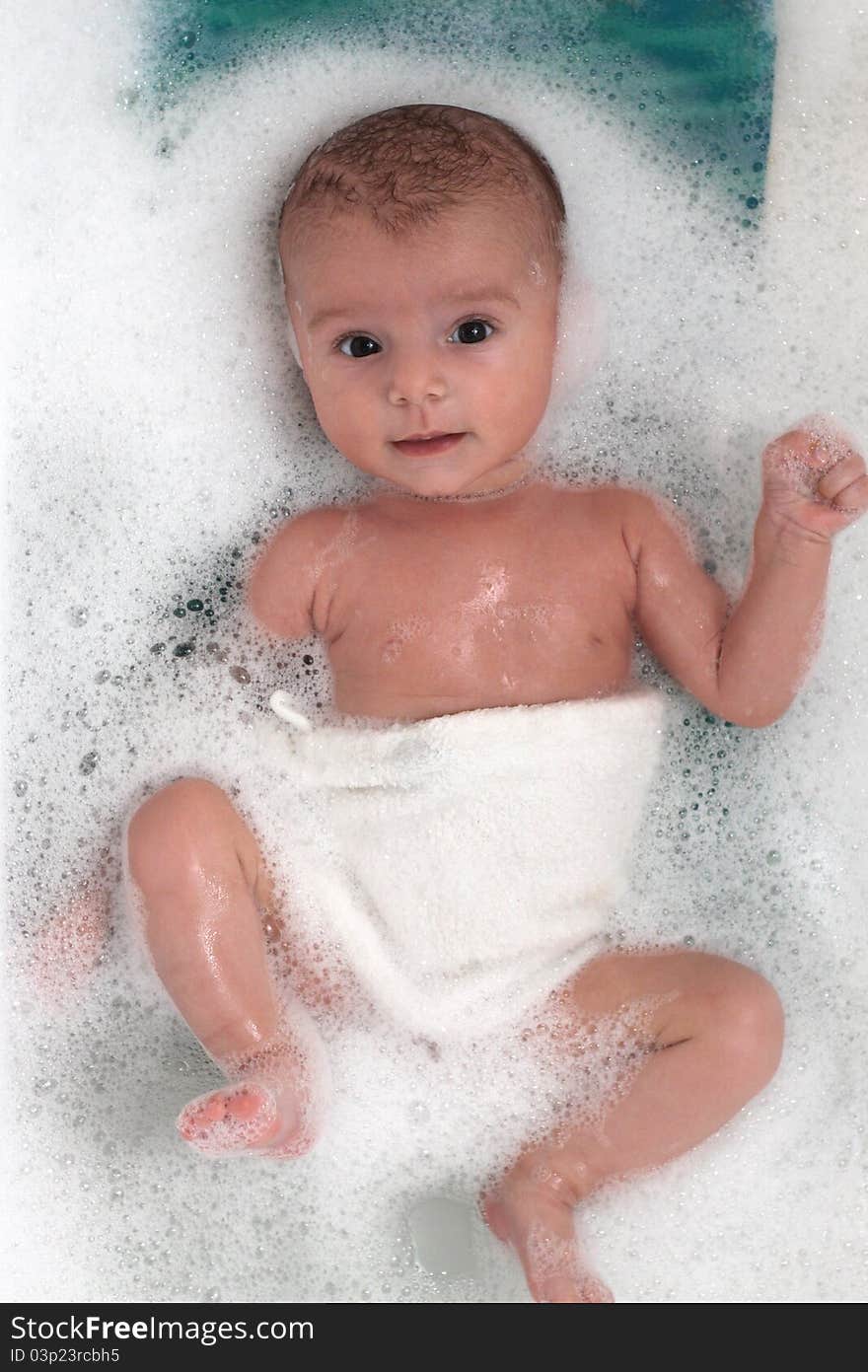 Cute baby girl bathing in soap bubbles