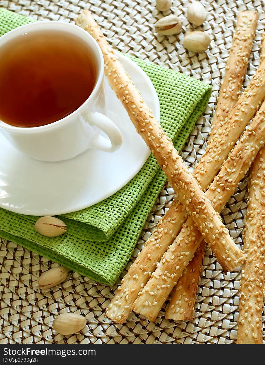 Cup of tea and crispy straw on table