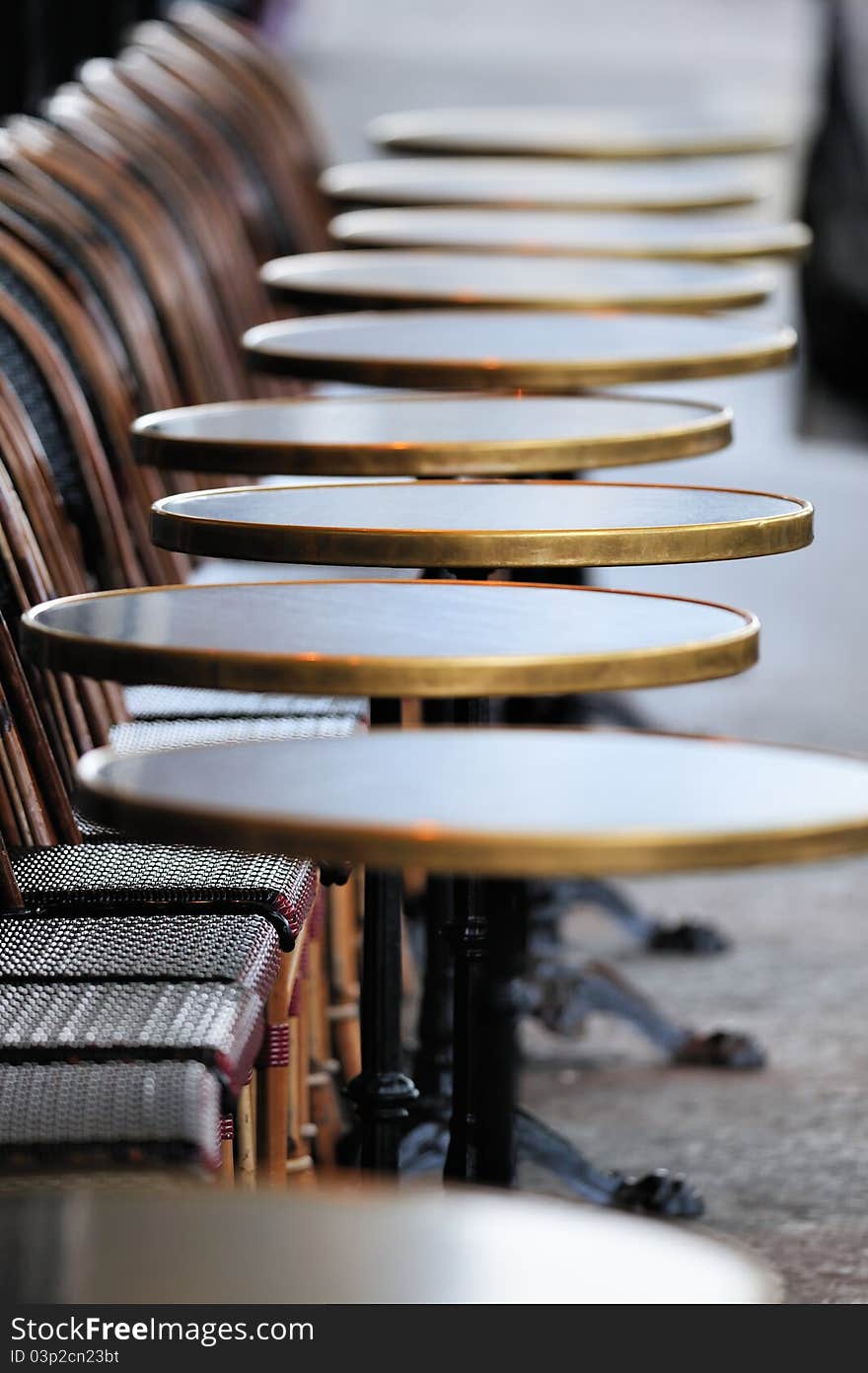 Several round tables in the typical cafe in Paris. Photo with tilt-shift effect