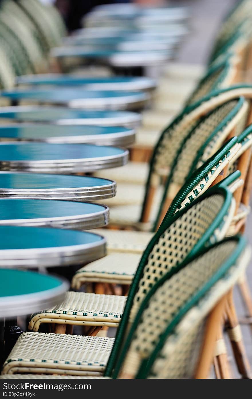 Several round tables and chairs in cafe in Paris. Photo with tilt-shift effect