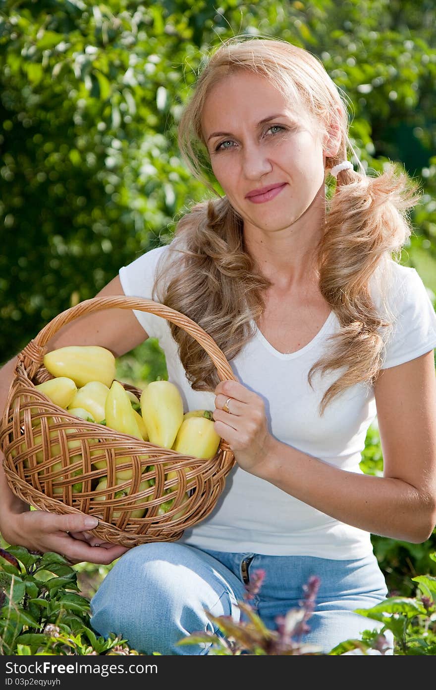 Young woman holding vegetables in the garden