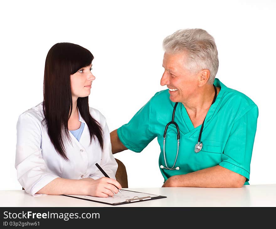 Cute doctor sits with nurse at table. Cute doctor sits with nurse at table