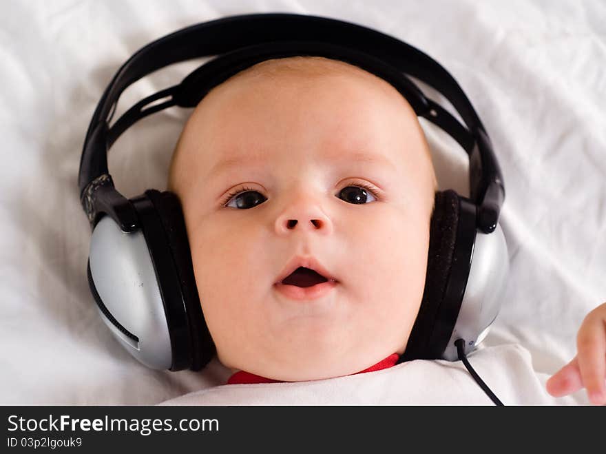 Cute little baby with headphones on white. Cute little baby with headphones on white