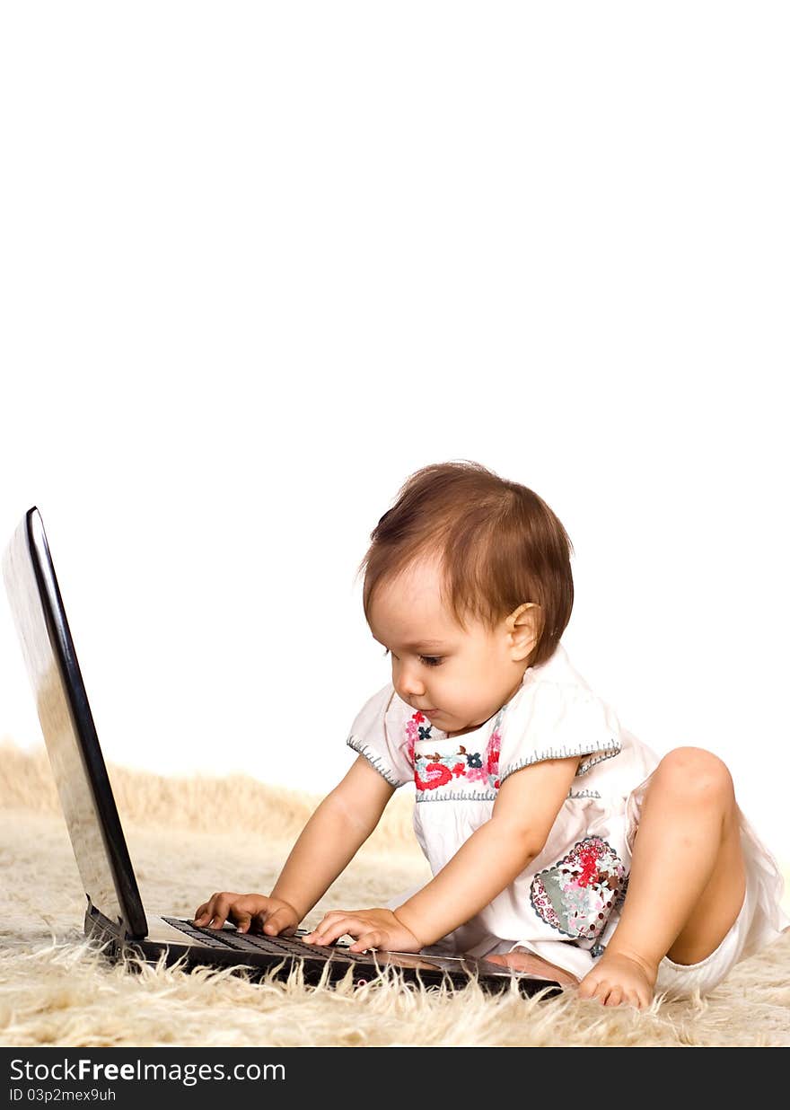 Cute little girl with laptop on a carpet. Cute little girl with laptop on a carpet