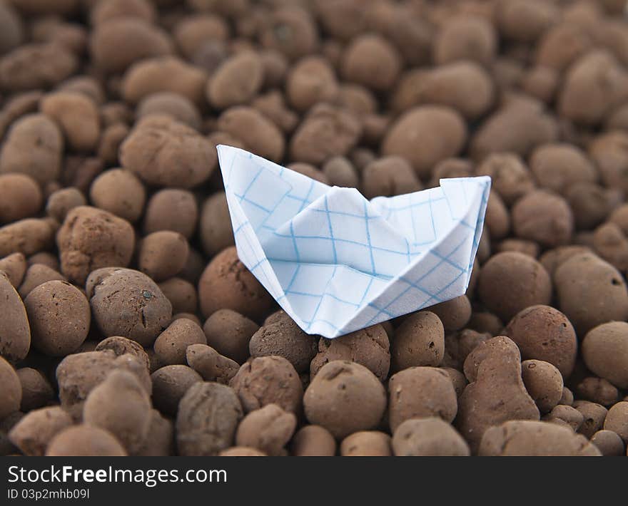 White paper boat on the rocks