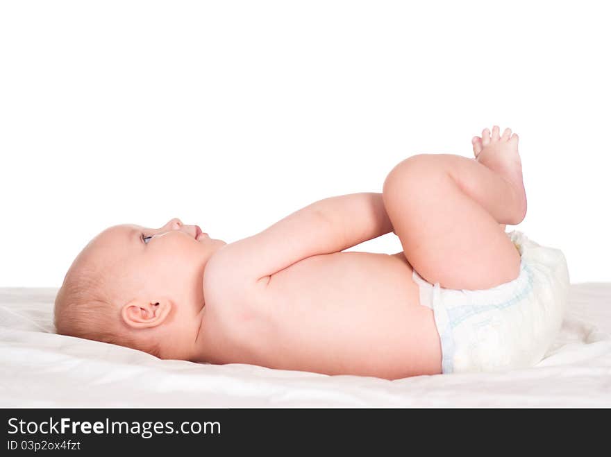 Portrait of a cute baby lying on bed on a white. Portrait of a cute baby lying on bed on a white