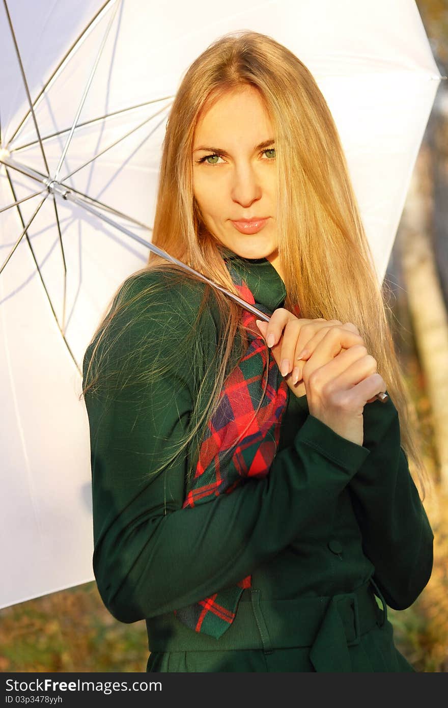 Young blond girl with white umbrella in autumn park in the evening. Young blond girl with white umbrella in autumn park in the evening