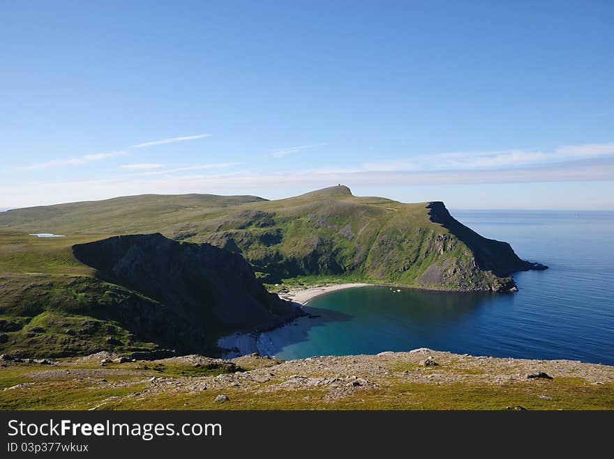 Soroya is a large island in western Finnmark of Norway. There are blue bays, steep hills overgrown with moss and famous sand beaches. Soroya is a large island in western Finnmark of Norway. There are blue bays, steep hills overgrown with moss and famous sand beaches.