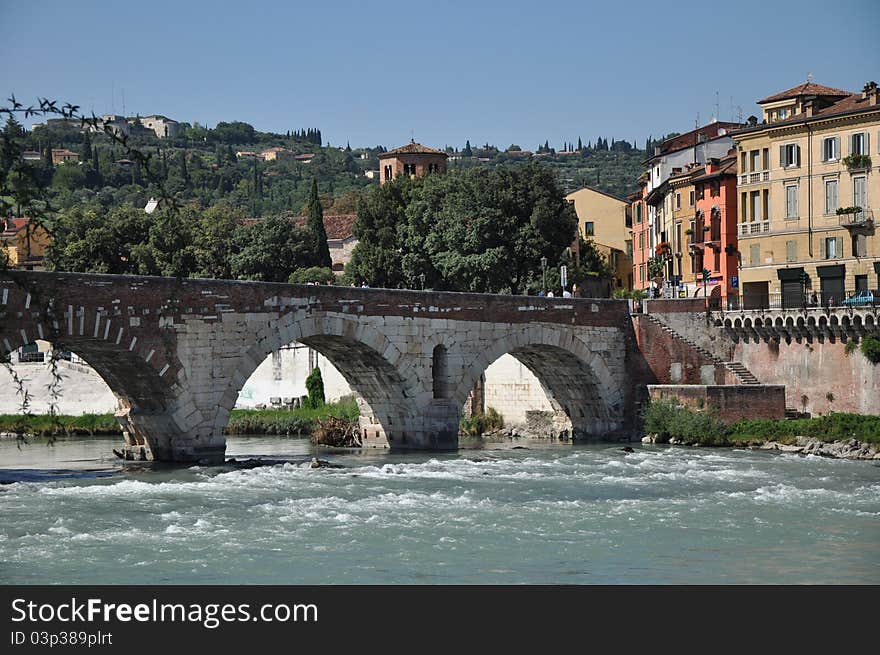 Bridge above the river, green heel and buildings in summer. Bridge above the river, green heel and buildings in summer.