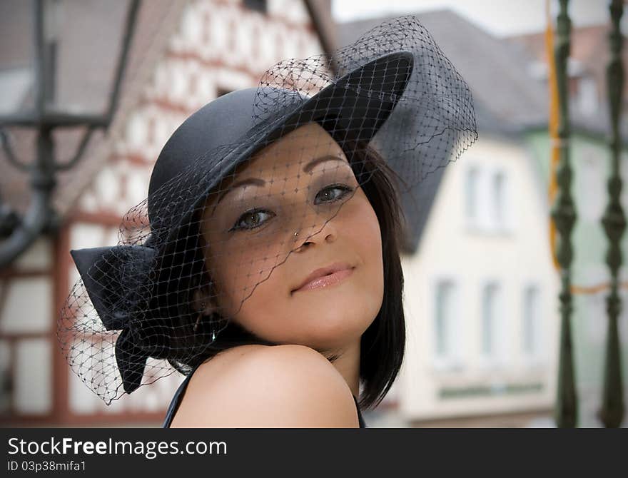 The girl in a hat in an old city in a province